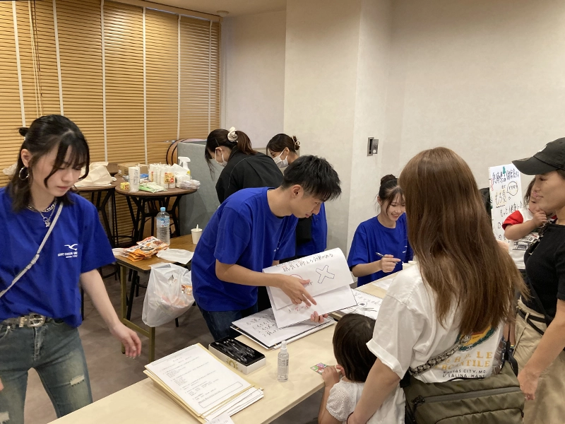 子どもたちにクイズを出す学生