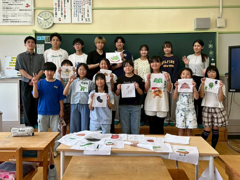 完成したゼッケンを手に記念撮影する西紀北小の児童と菊川ゼミ生