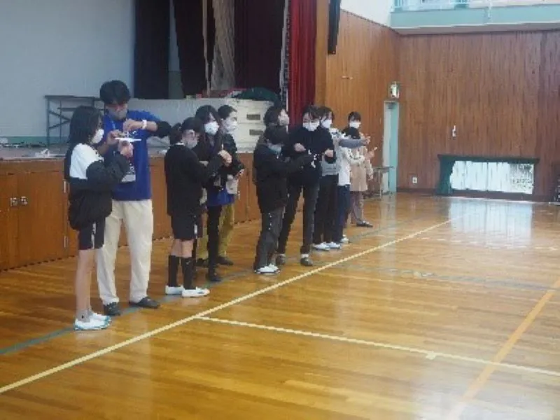 小学生に飛ばし方を教える学生スタッフ