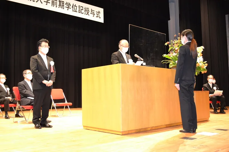 佐藤学長が読み上げる学位記の言葉を聞く卒業生