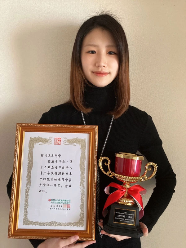 優勝カップと表彰状を手に笑顔の猪川恵美さん