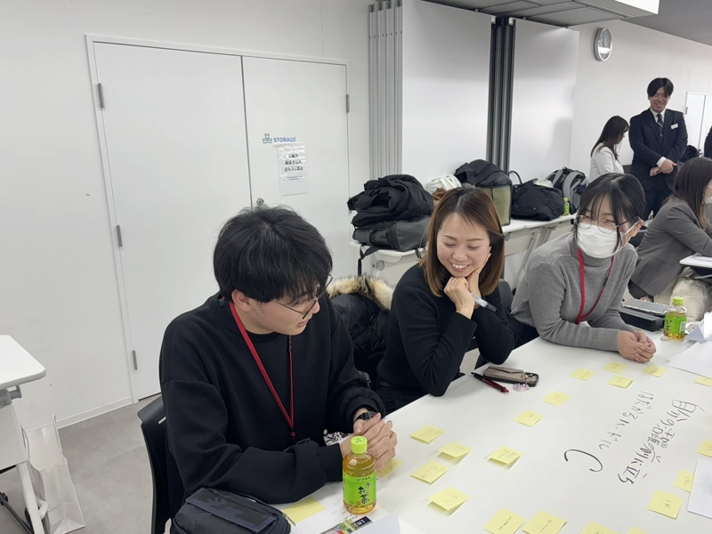 社会人の参加者と交流する学生2人