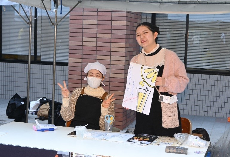 模擬店でポーズを取る学生たち