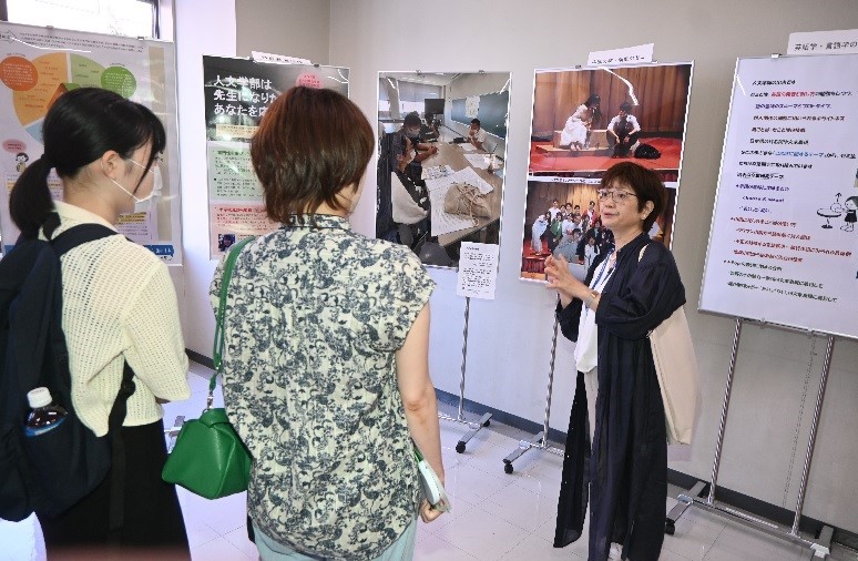 人文学部の展示コーナーでは中山文教授がゼミで取り組んだ戯曲「リア王」公演について参加者に説明