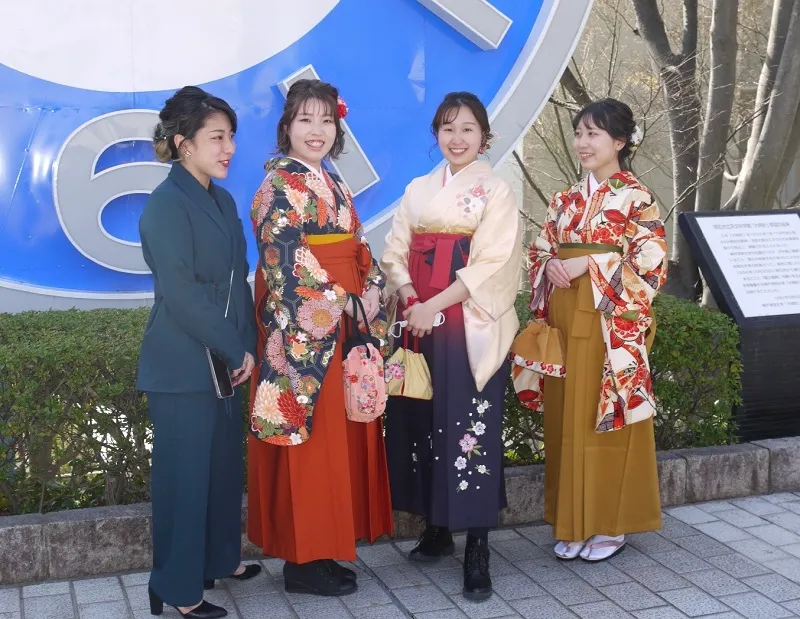 大時計の前で記念撮影する卒業生
