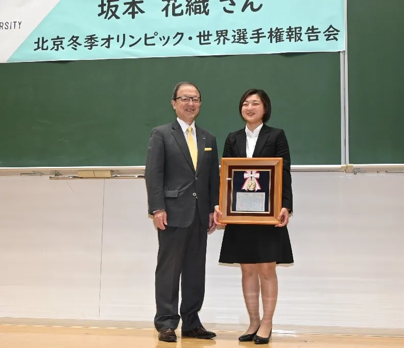 西本誠實理事長(左)から理事長賞を授与され笑顔の坂本花織さん