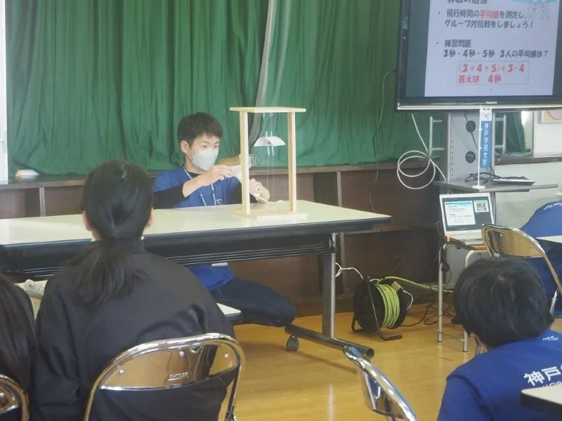 装置を使って揚力の実験をする学生スタッフ
