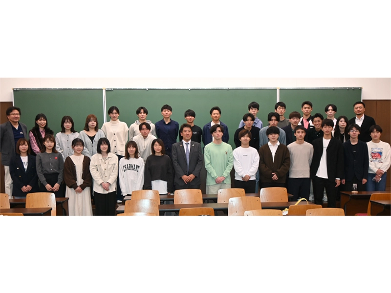 安本社長を囲んで記念撮影する田中ゼミと柳ゼミの学生たち
