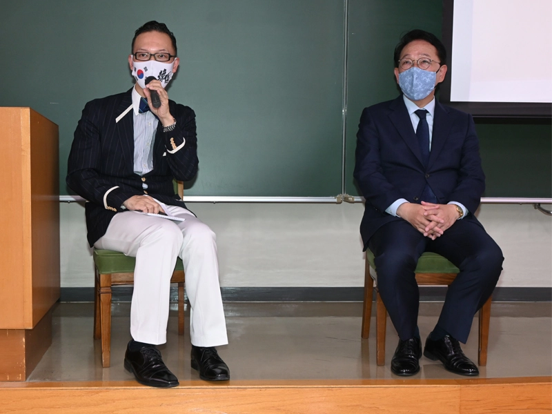 学生からの質問に答える梁総領事(右)。左は国際交流センターの岡部所長
